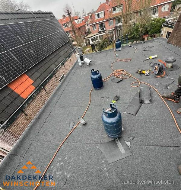 Daklekkage repareren met brandgereedschap op plat dak in Winschoten