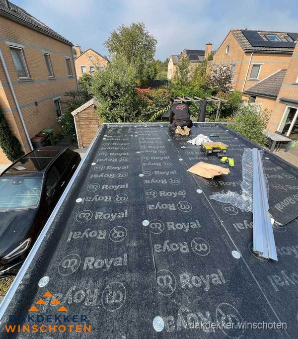 Dakdekker aan het werk op plat dak renovatie in Winschoten