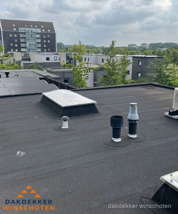 Groot plat dak met lichtkoepel en dakdoorvoeren in Winschoten