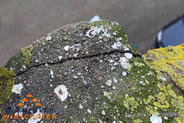 Beschadigde en verweerde nokvorst met scheuren en mos in Winschoten Beschadigde en verweerde nokvorst met scheuren en mos in Winschoten