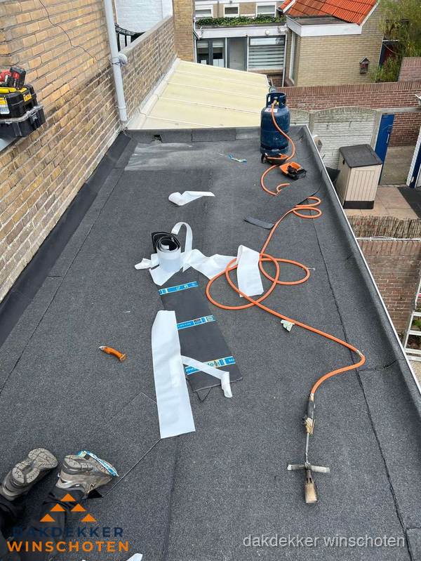 Dakdekkers bezig met bitumen dakbedekking in Winschoten