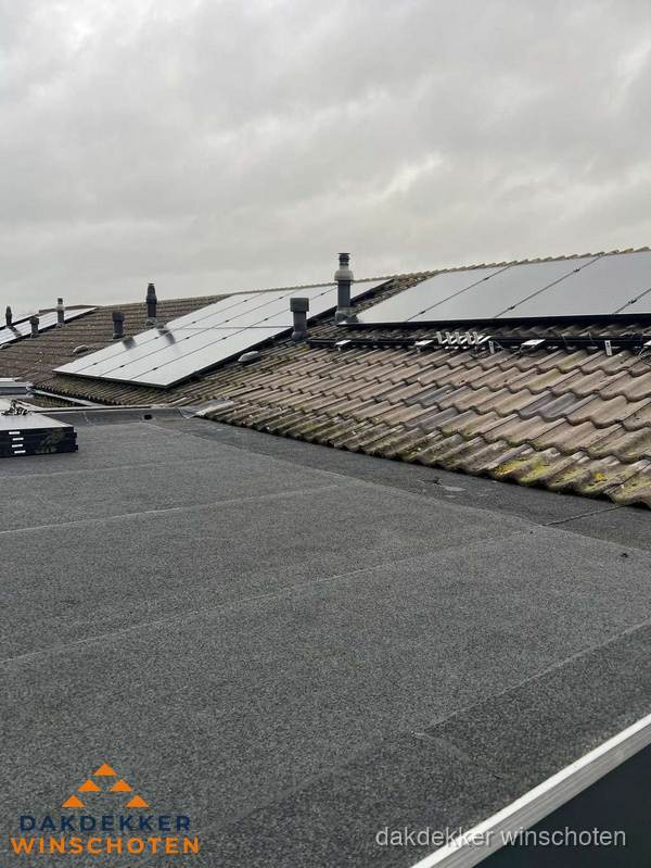 Bitumen dakbedekking op plat dak met aansluitend pannendak en zonnepanelen in Winschoten
