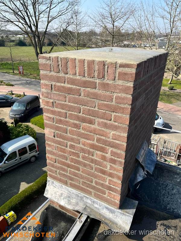 Gemetselde schoorsteen met loodaansluiting op dak in Winschoten Gemetselde schoorsteen met loodaansluiting op dak in Winschoten