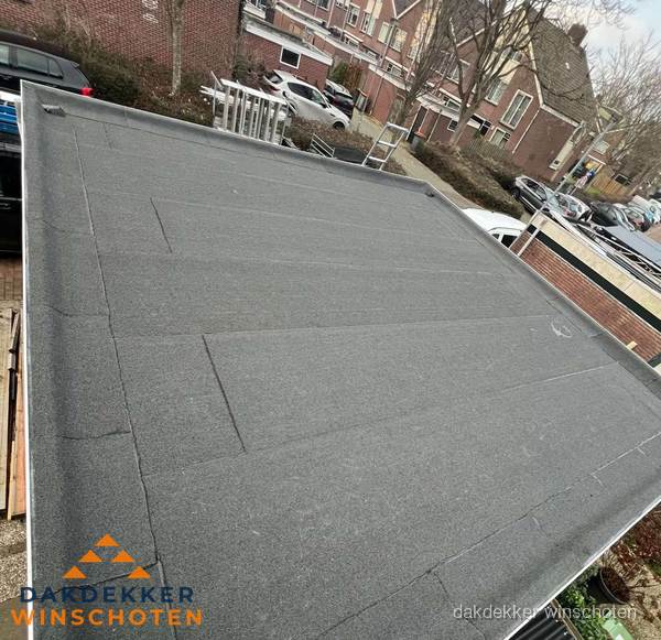 Nieuwe bitumen dakbedekking op plat dak van garage in Winschoten