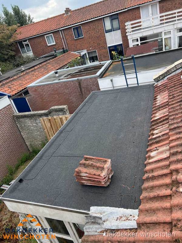 Plat dak aanbouw met bitumen naast schuin pannendak in Winschoten Plat dak aanbouw met bitumen naast schuin pannendak in Winschoten