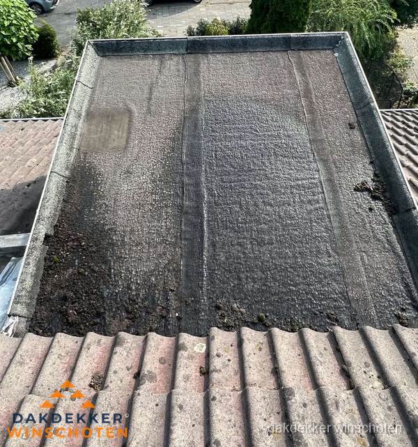 Verouderd plat dak met bitumen en slijtage voor lekkage inspectie in Winschoten Verouderd plat dak met bitumen en slijtage voor lekkage inspectie in Winschoten
