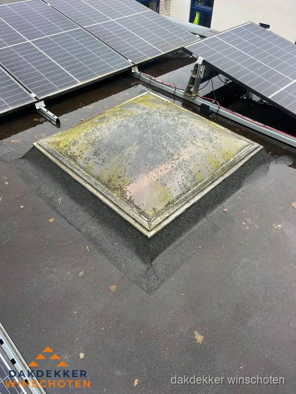 Vervuilde lichtkoepel op plat dak met zonnepanelen in Winschoten Vervuilde lichtkoepel op plat dak met zonnepanelen in Winschoten