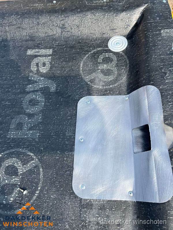 Dakdoorvoer met metalen afvoerplaat op bitumen dak in Winschoten
