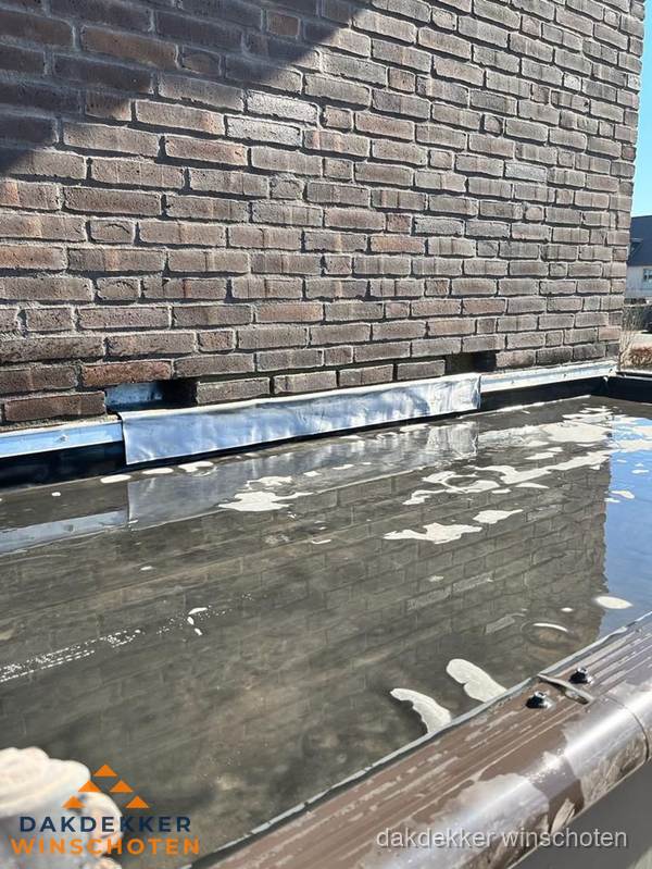 Stilstaand water op plat dak door slechte afwatering in Winschoten Stilstaand water op plat dak door slechte afwatering in Winschoten