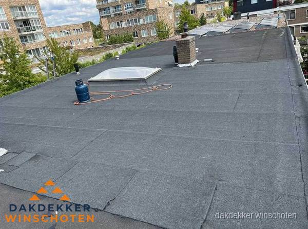 Bitumen dakbedekking op plat dak met lichtkoepel en schoorsteen in Winschoten Bitumen dakbedekking op plat dak met lichtkoepel en schoorsteen in Winschoten